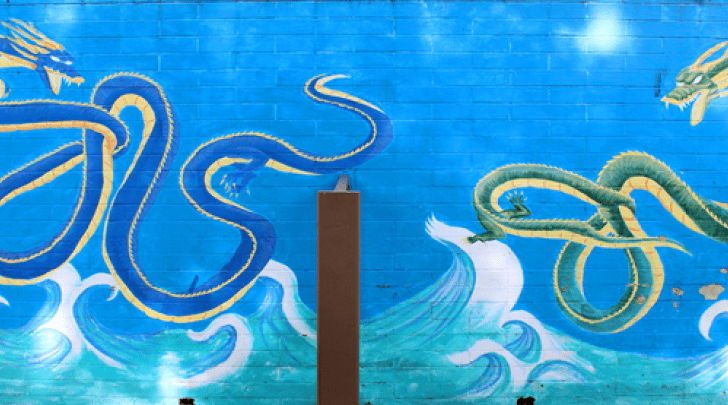 mural of green and blue dragons spelling CAPAS